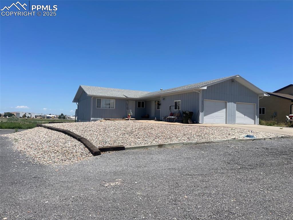 Caption: Ranch-style house featuring an attached garage and concrete driveway