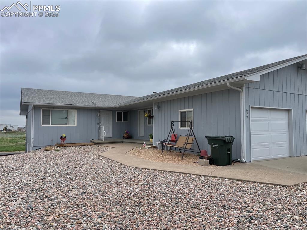 Image 2 of 4: Back of house featuring roof with shingles and an attached garage