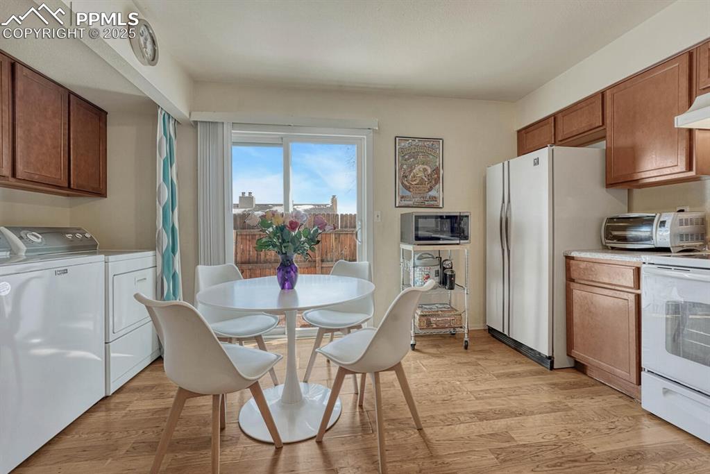 Image 6 of 22: Kitchen equipped with washing machine and clothes dryer, stone countertops,