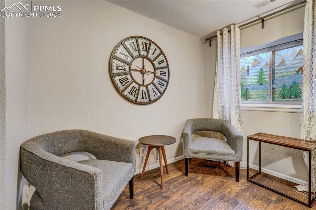 Image 25 of 35: Sitting area in the recreation room in the basement with good lighting, mur