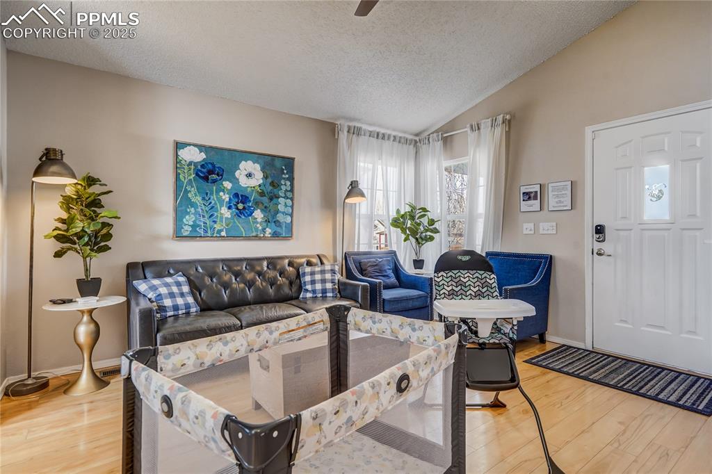 Image 3 of 35: Living area featuring a vaulted ceiling, a two sided fireplace, light wood 