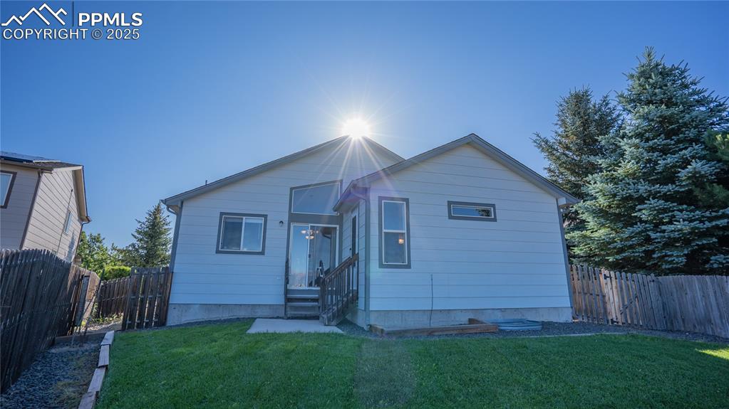 Image 33 of 35: Rear view of property with a fenced backyard and entry steps