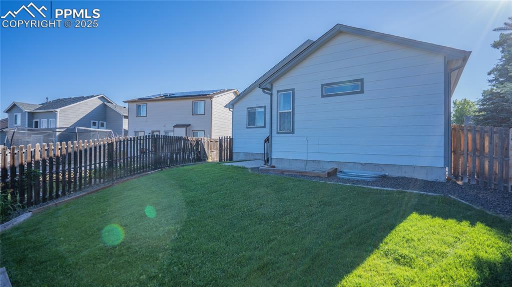 Image 34 of 35: Back of house featuring a fenced backyard