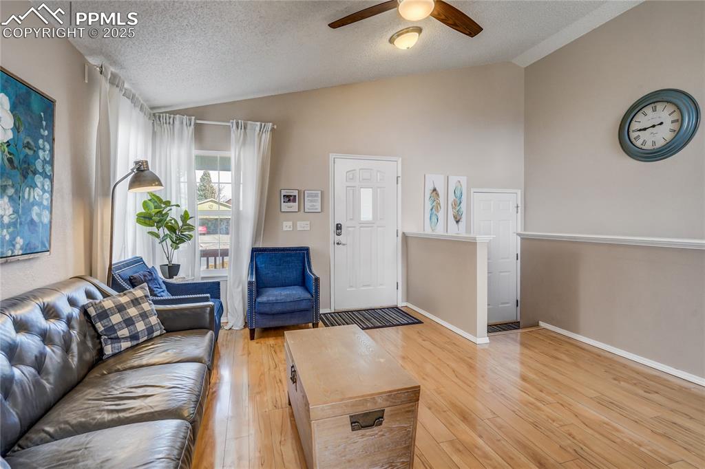 Image 4 of 35: Living room featuring vaulted ceiling and light wood 