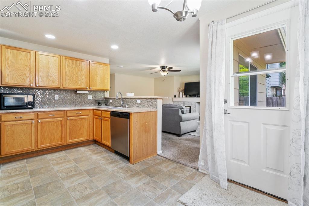 Image 14 of 46: Kitchen featuring stainless steel dishwasher, black microwave, open floor p