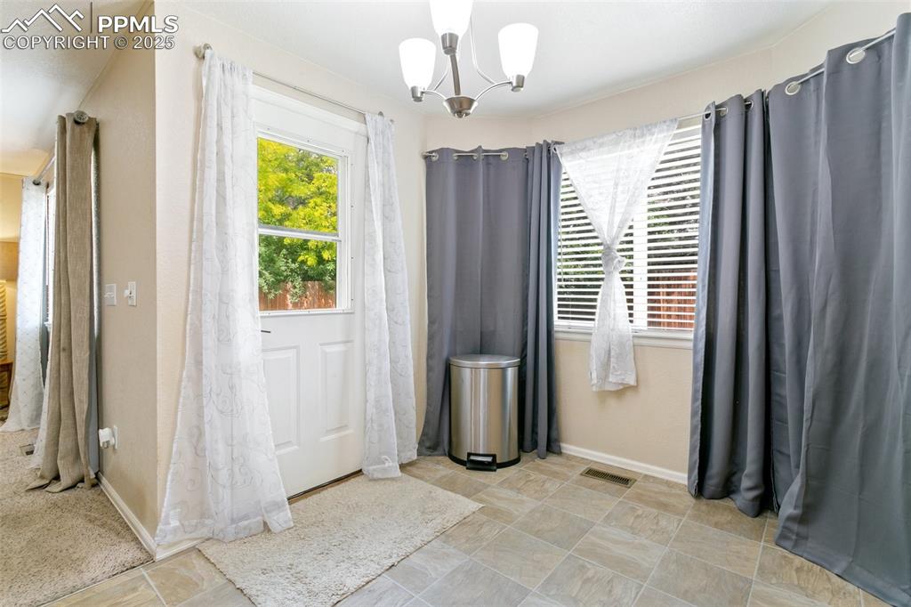 Image 16 of 46: Unfurnished dining area with a chandelier and baseboards