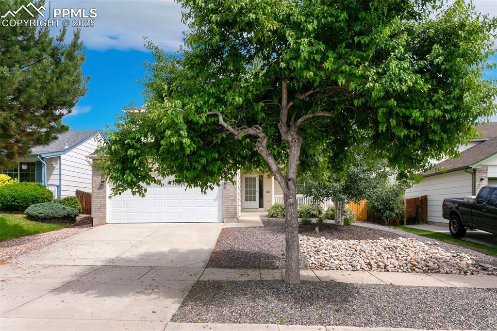 Image 2 of 46: Obstructed view of property with concrete driveway, a garage, and brick sid