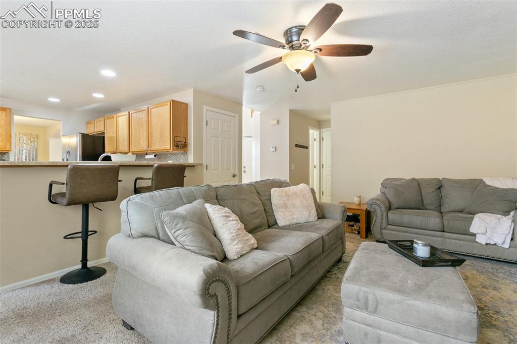 Image 20 of 46: Carpeted living area with a ceiling fan and recessed lighting