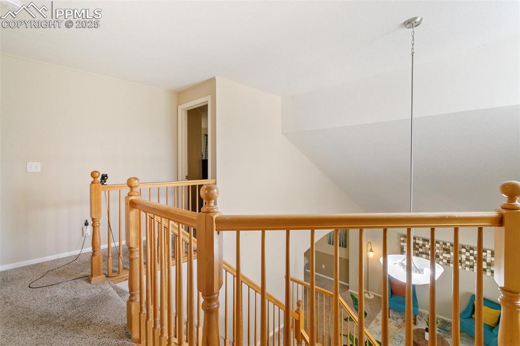 Image 25 of 46: Hall featuring an upstairs landing and carpet flooring