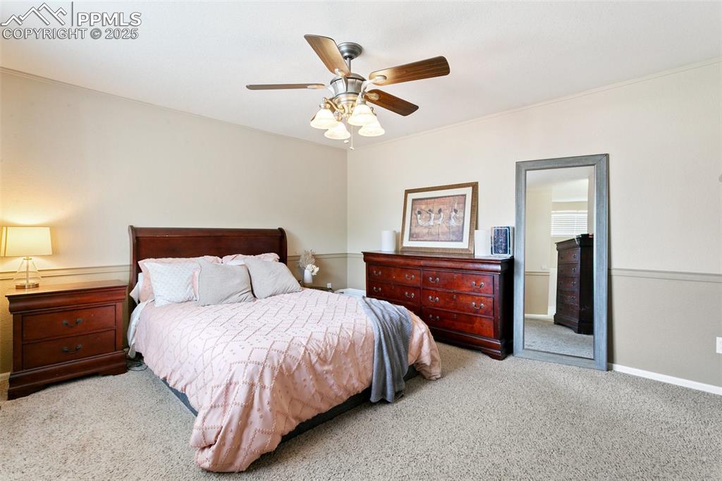 Image 28 of 46: Carpeted bedroom with baseboards and ceiling fan