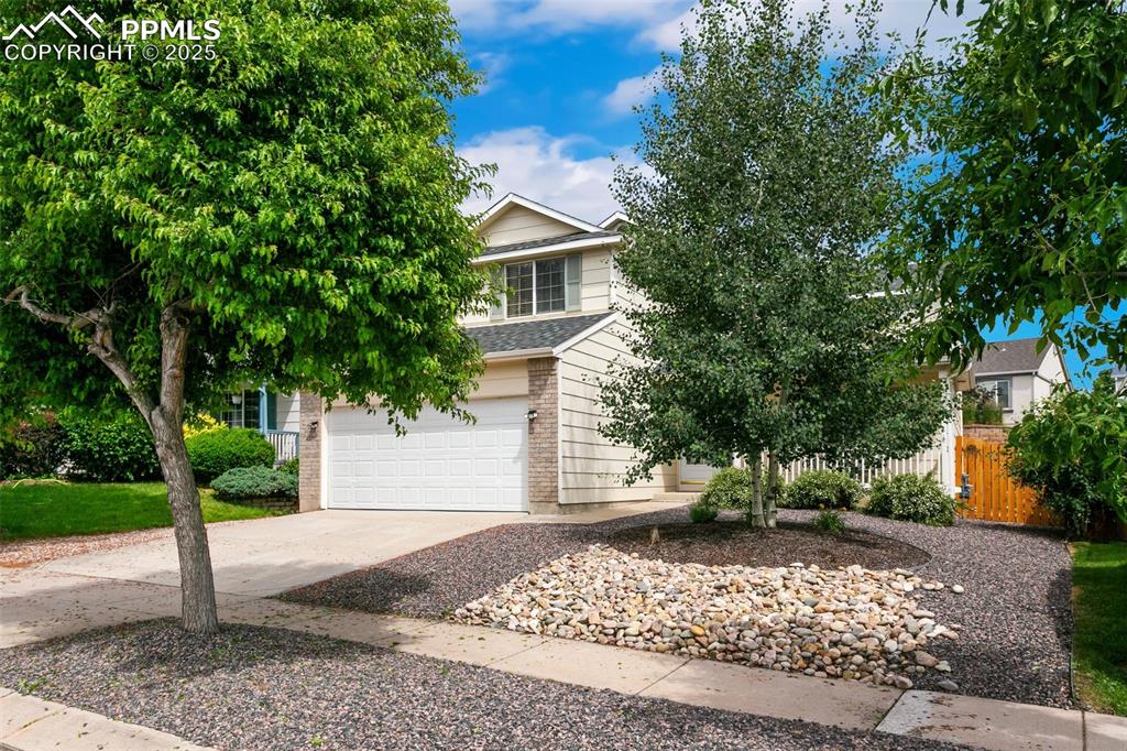 Image 3 of 46: Obstructed view of property with driveway, a garage, a shingled roof, and b