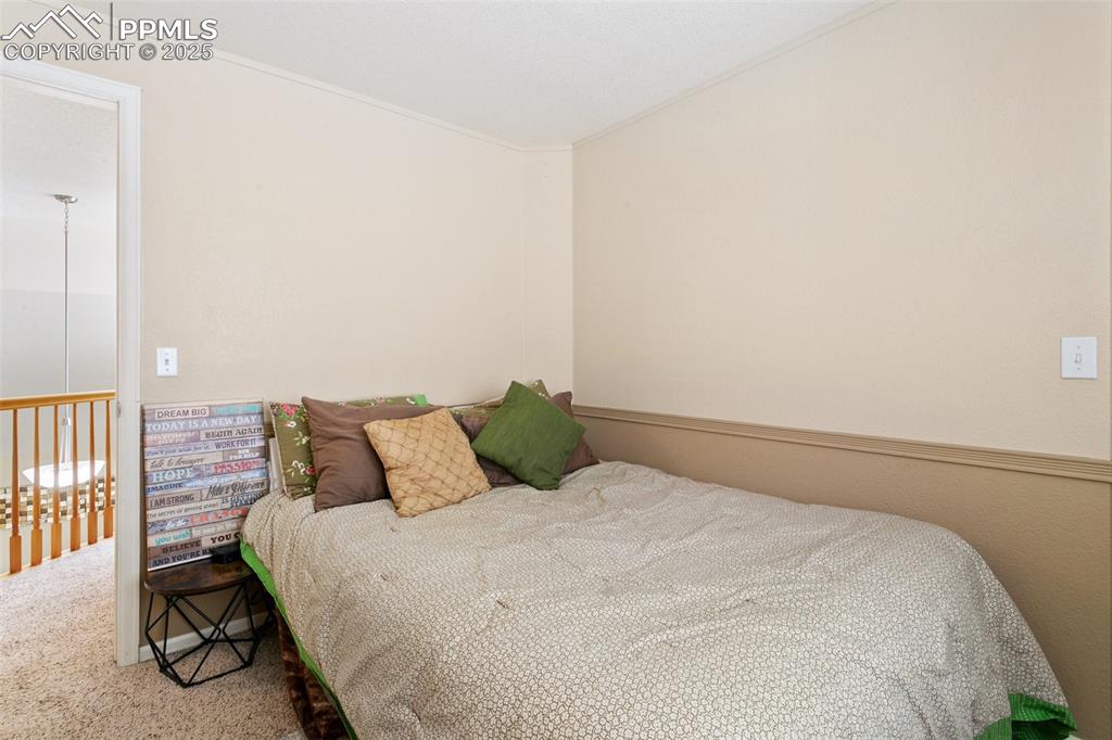 Image 39 of 46: Carpeted bedroom with ornamental molding