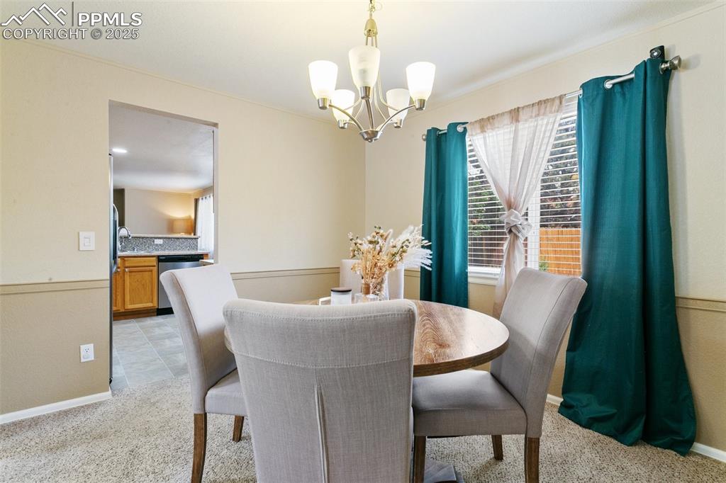 Image 7 of 46: Dining space featuring a chandelier and light colored carpet