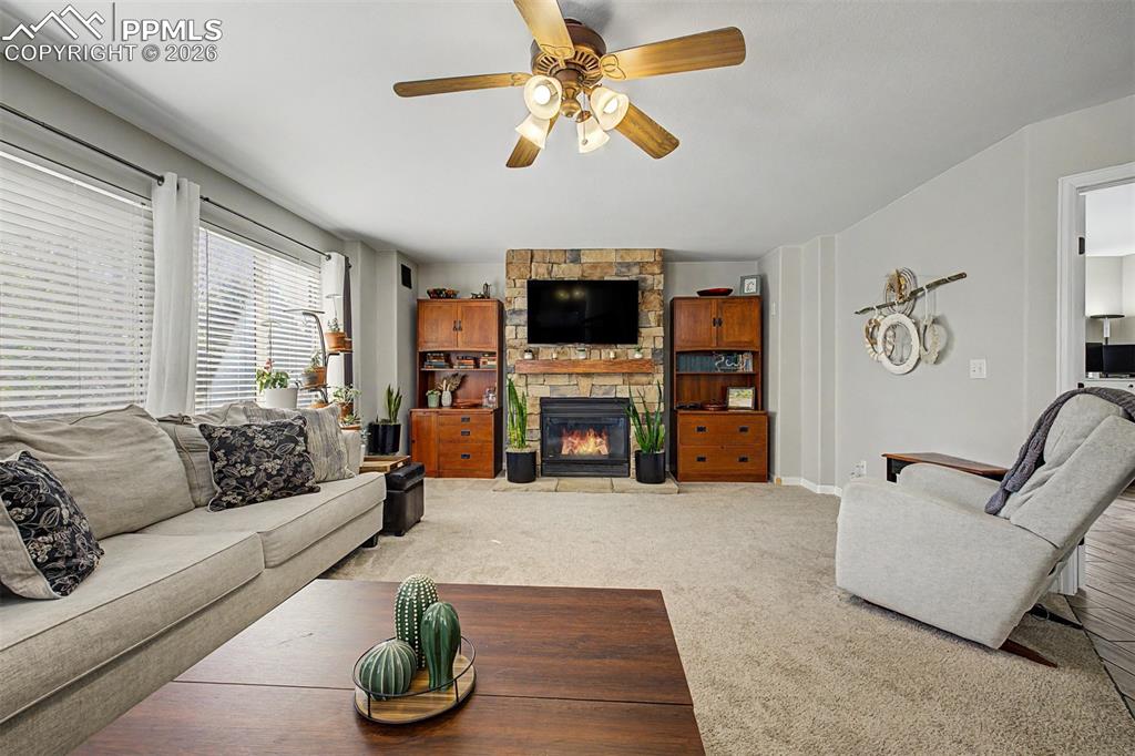 Image 16 of 49: The family room is anchored by a stunning floor-to-ceiling stacked-stone fi