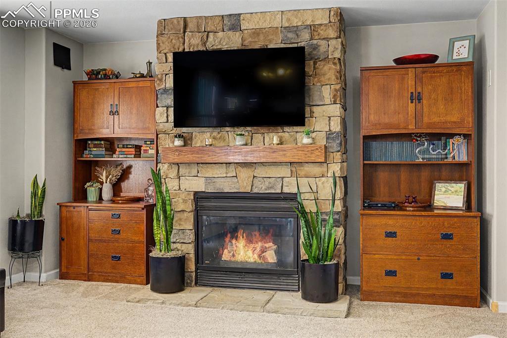Image 17 of 49: The stacked-stone fireplace surround, flanked by craftsman-style wood cabin