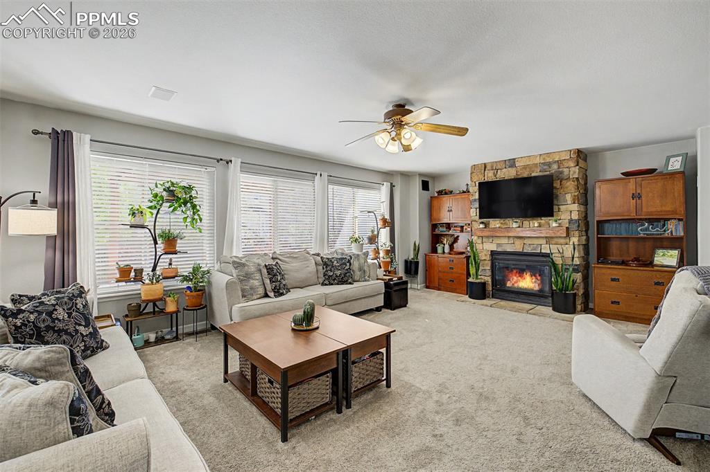 Image 18 of 49: Flooded with natural light from a wall of windows, the family room comforta
