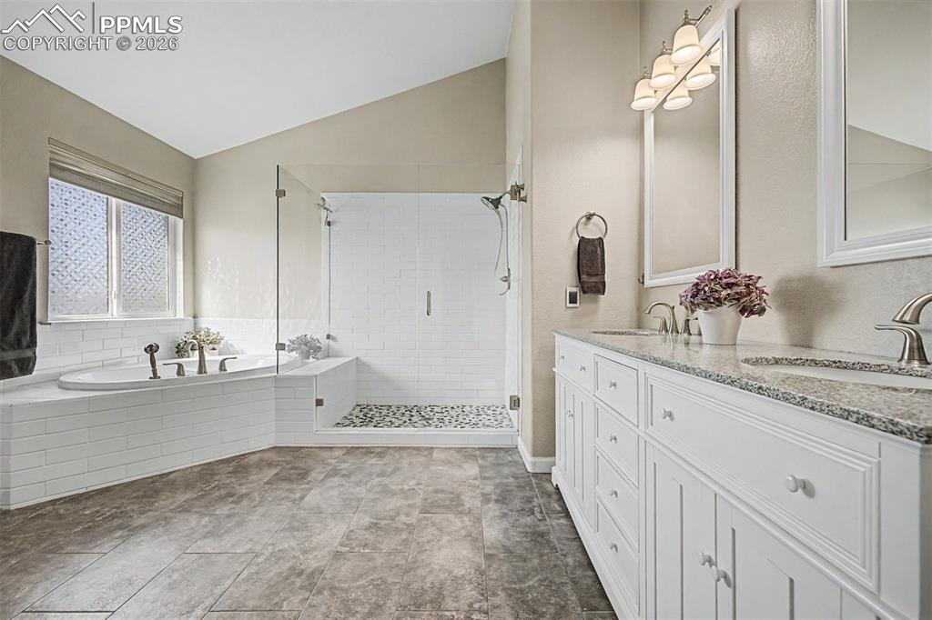 Image 25 of 49: The full primary bath showcases a double vanity with granite countertops an