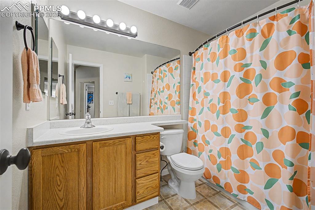 Image 27 of 49: A well-appointed hall bath serves the secondary bedrooms with a wide vanity