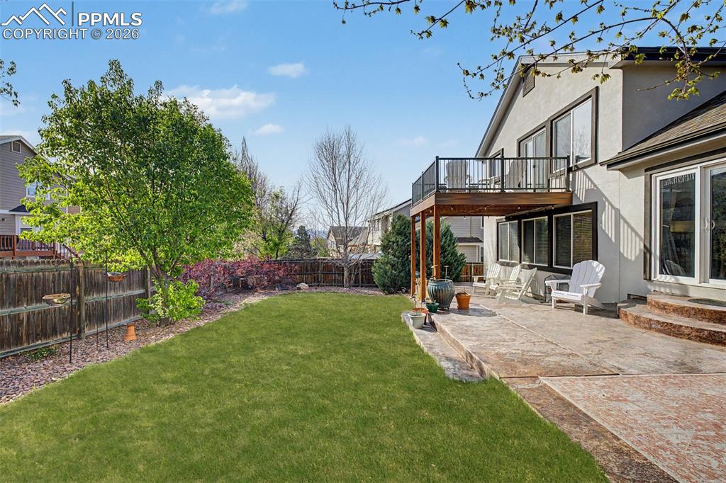 Image 38 of 49: The fully fenced backyard is a private outdoor haven, featuring a lush gree