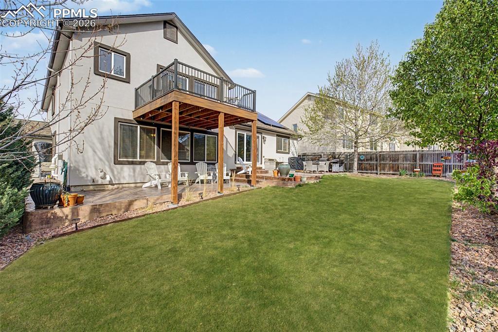 Image 41 of 49: A closer look at the covered patio beneath the pergola reveals its connecti