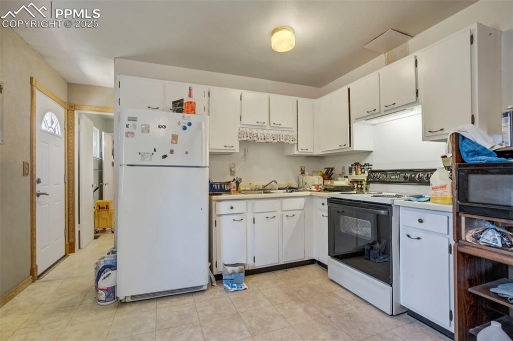 Image 10 of 38: Kitchen with white appliances, white cabinetry, light countertops, and ligh