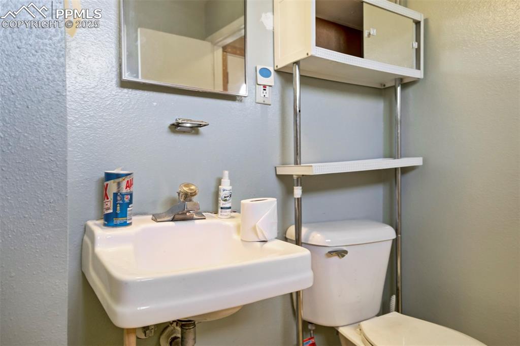 Image 14 of 38: Bathroom featuring a textured wall and toilet
