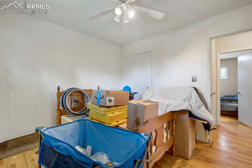 Image 19 of 38: Bedroom featuring light wood-style floors, a ceiling fan, and a textured ce