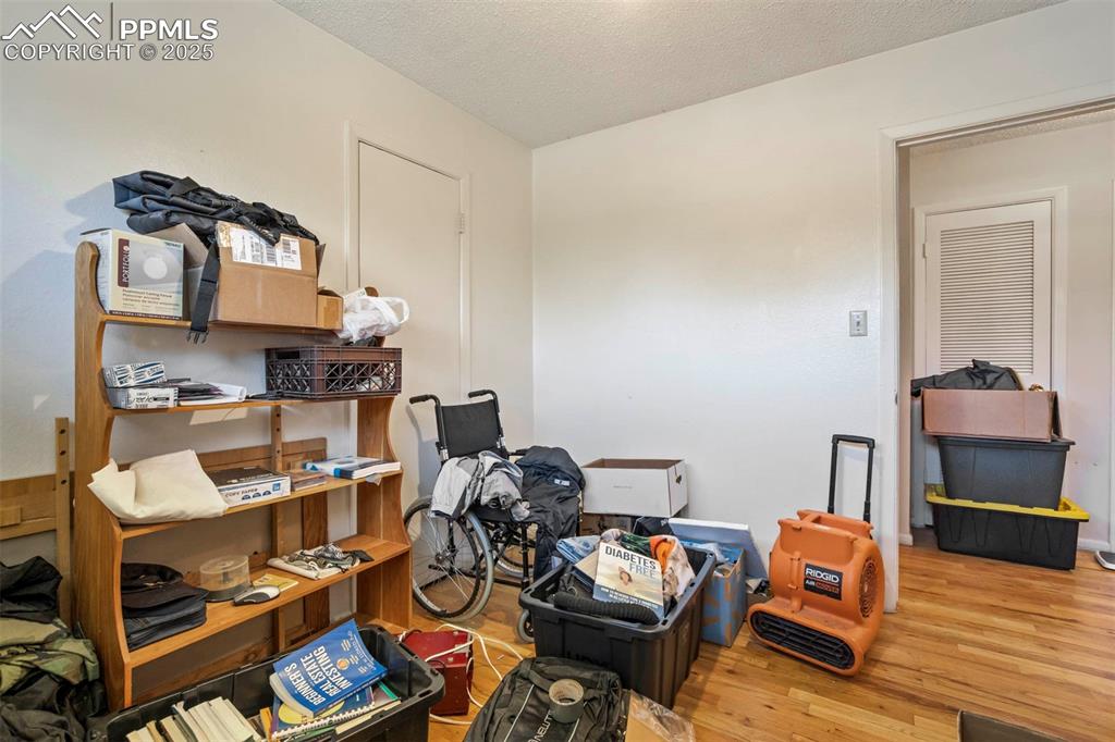 Image 22 of 38: Misc room with wood finished floors and a textured ceiling