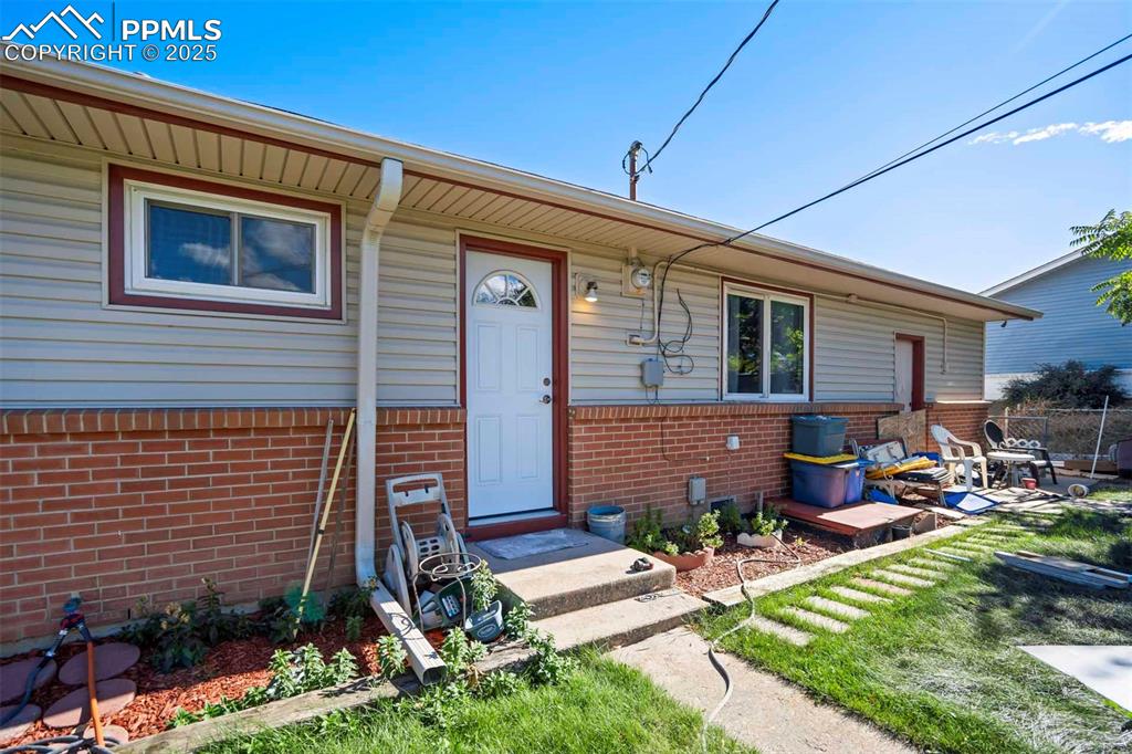 Image 27 of 38: View of exterior entry with brick siding