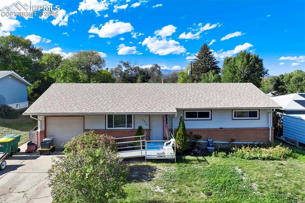 Image 3 of 38: View of front of house featuring brick siding, concrete driveway, covered p