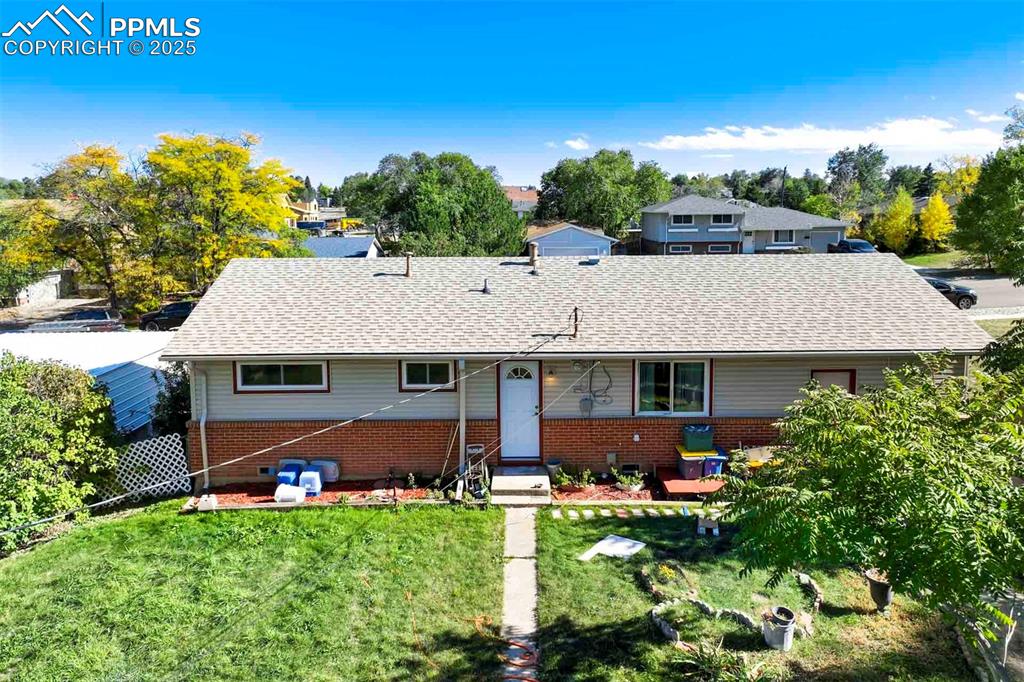 Image 34 of 38: Ranch-style house with brick siding, a front lawn, and a shingled roof