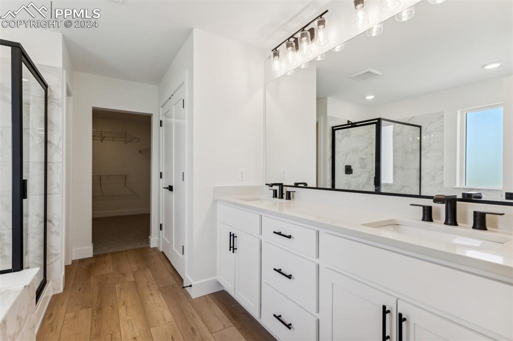 Image 8 of 17: Bathroom featuring hardwood / wood-style floors, vanity, and a shower with
