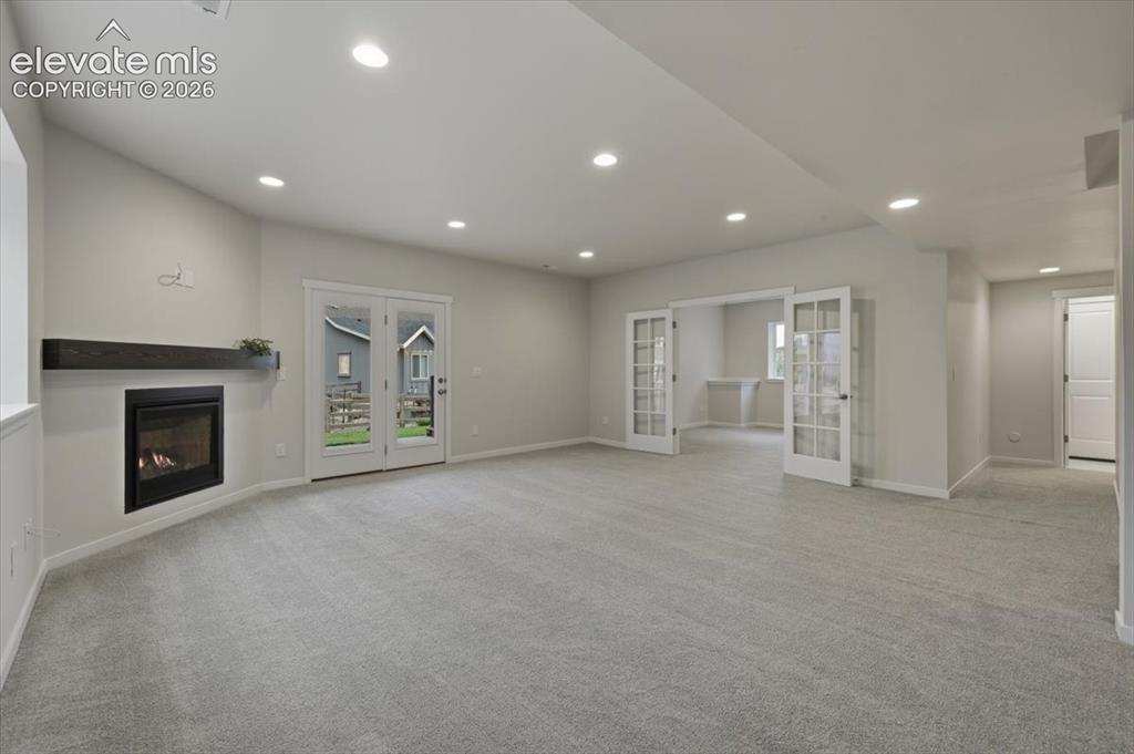 Image 40 of 50: Basement family room- french doors are the 6th bedroom/flex space - hallway