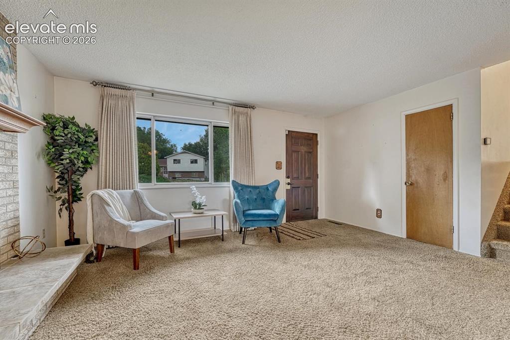 Image 10 of 36: living room looking at entry and stairs going to upper level
