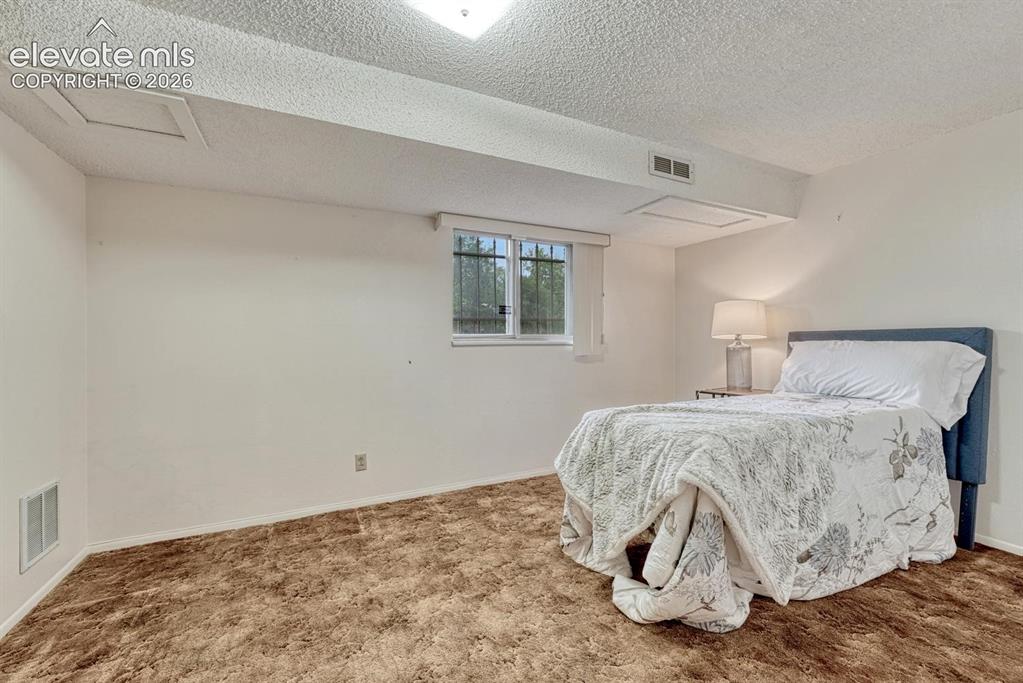 Image 19 of 36: lower level office staged as a bedroom