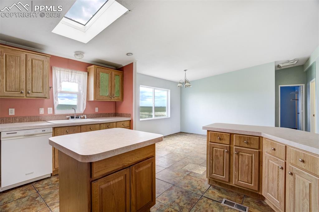 Image 17 of 49: Kitchen featuring dishwasher, light countertops, plenty of natural light, a