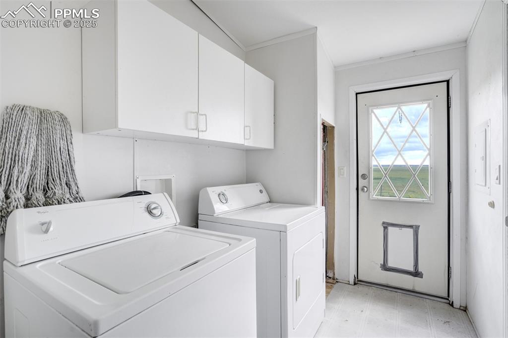 Image 19 of 49: Washroom featuring cabinet space, washing machine and dryer, ornamental mol
