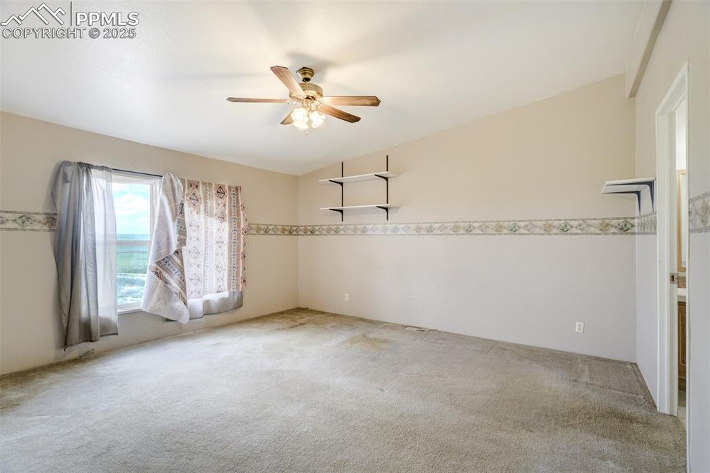 Image 20 of 49: Unfurnished room featuring carpet floors, a ceiling fan, and vaulted ceilin