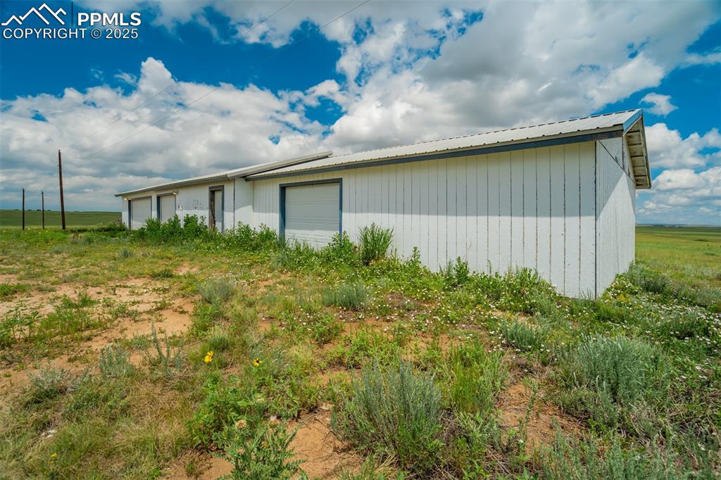 Image 33 of 49: View of side of home featuring an outbuilding, a detached garage, and a met