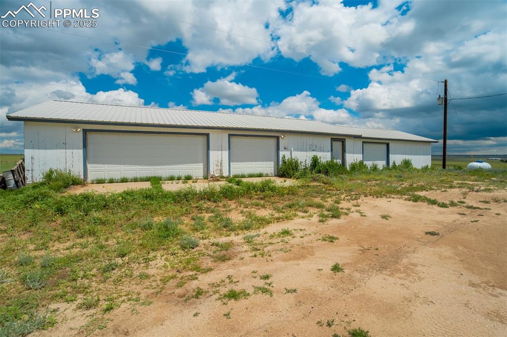 Image 34 of 49: View of front of property with a garage, a metal roof, and an outdoor struc