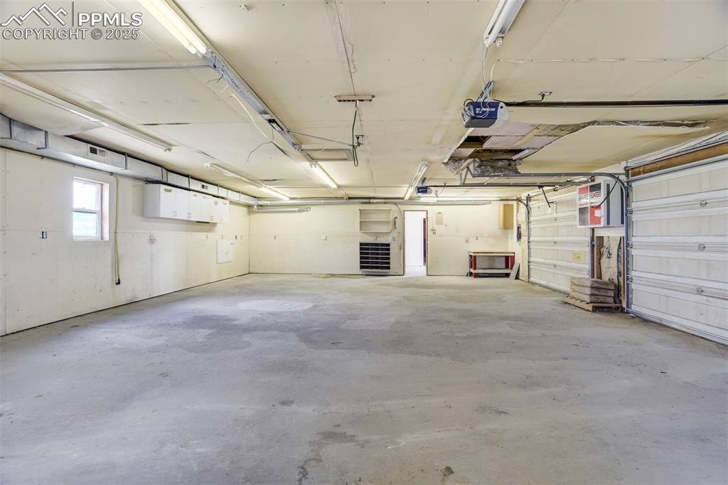 Image 44 of 49: Garage featuring a garage door opener