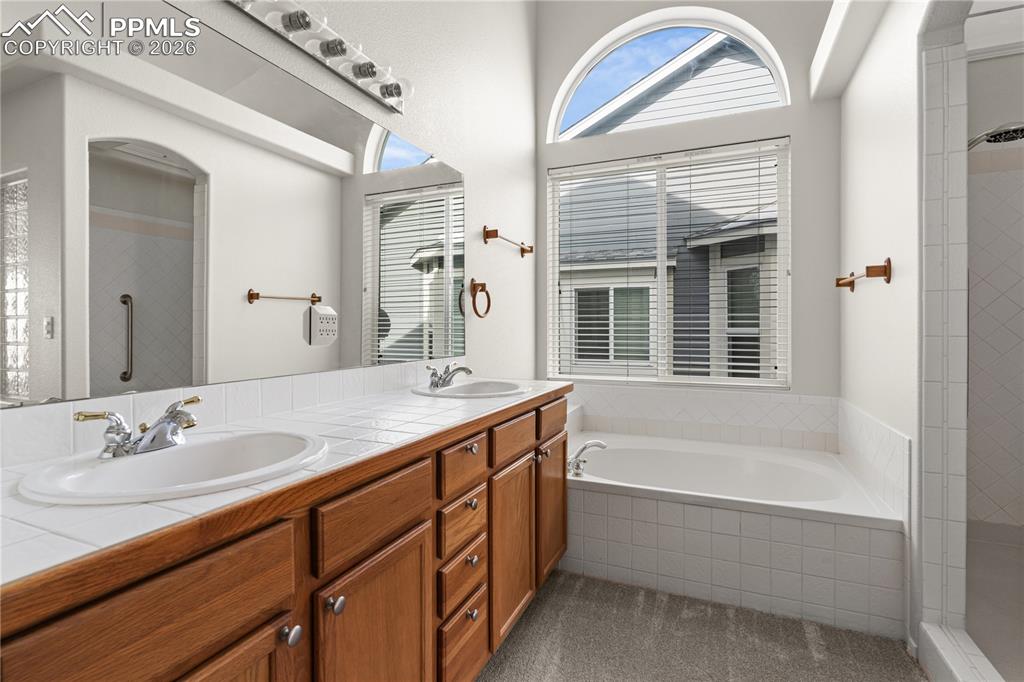 Image 23 of 39: The oversized bathroom with large soaking tub is luxurious.
