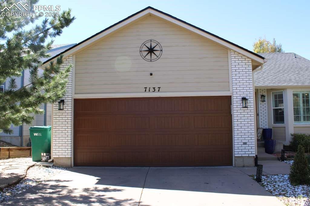 Image 2 of 30: Garage featuring concrete driveway