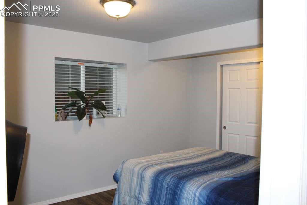 Image 29 of 30: Bedroom with dark wood finished floors and a closet
