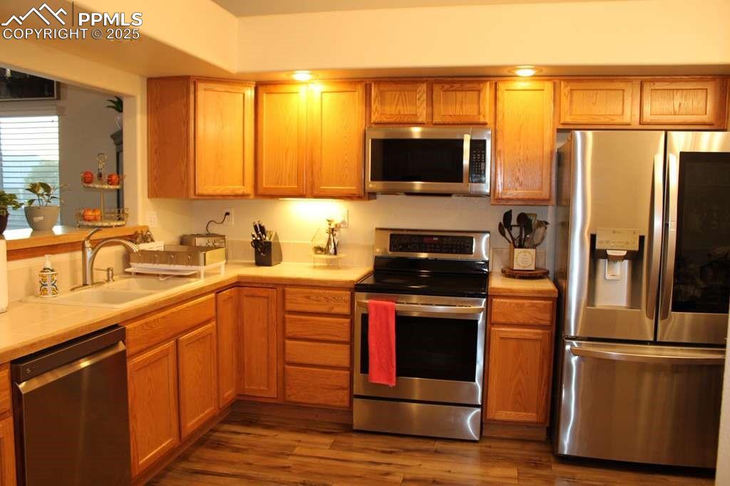 Image 6 of 30: Kitchen featuring appliances with stainless steel finishes, light counterto