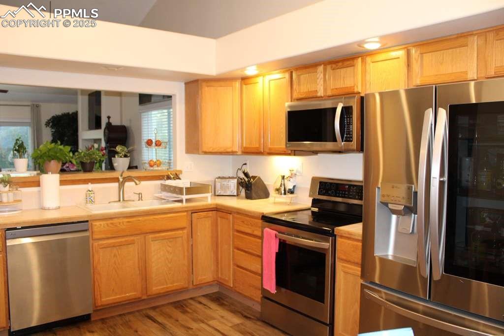 Image 8 of 30: Kitchen featuring stainless steel appliances, light countertops, light brow