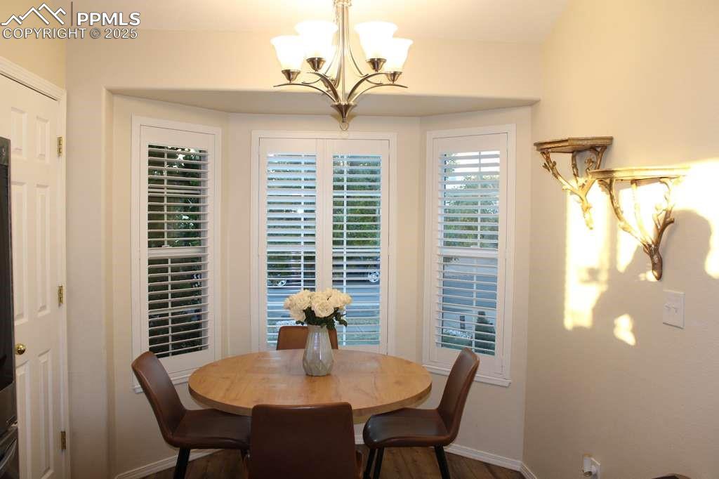 Image 9 of 30: Dining room with dark wood finished floors and a chandelier