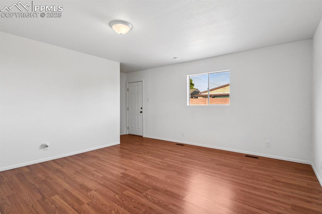 Image 13 of 33: Empty room with wood finished floors and baseboards
