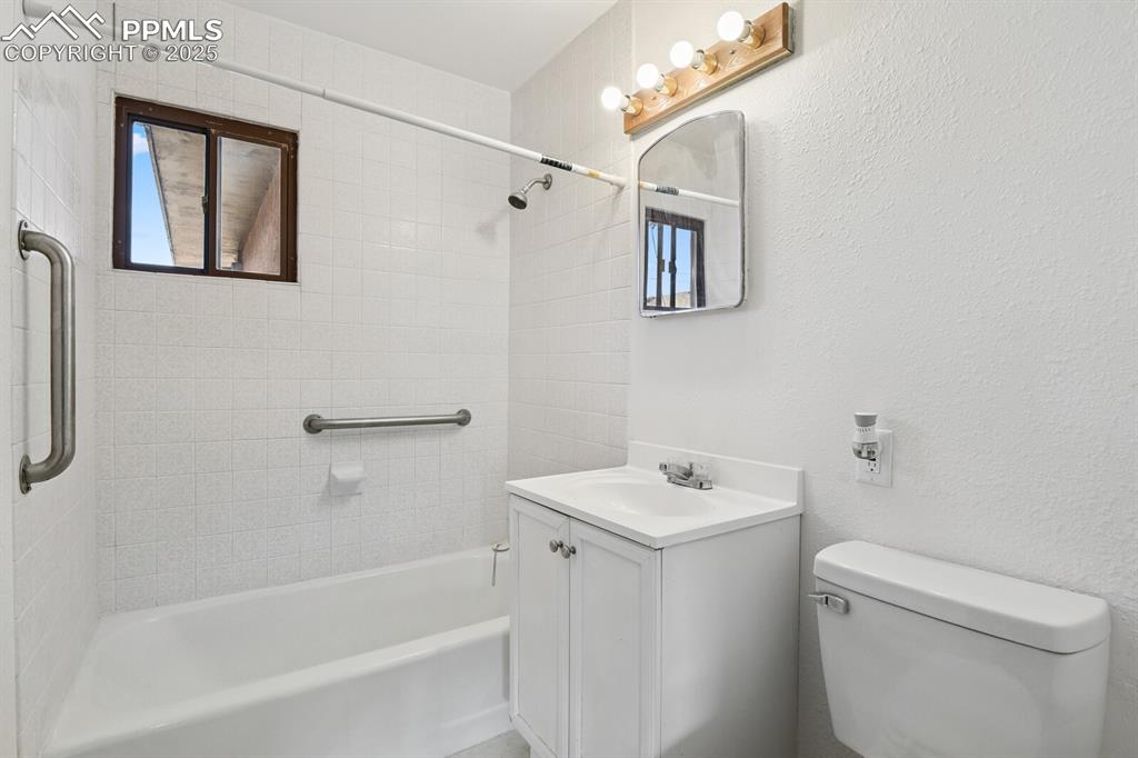 Image 21 of 33: Bathroom with washtub / shower combination, vanity, healthy amount of natur