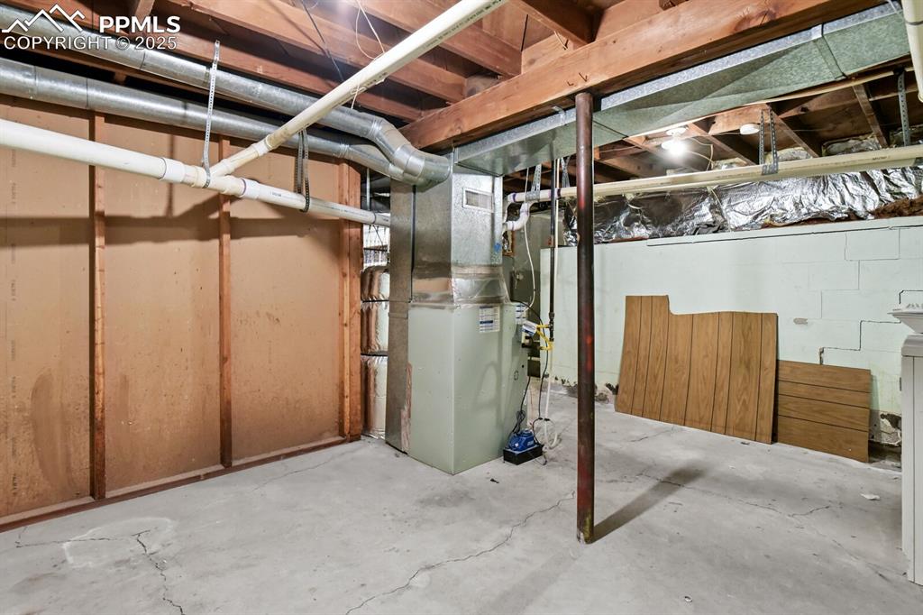 Image 25 of 33: Unfinished basement with heating unit